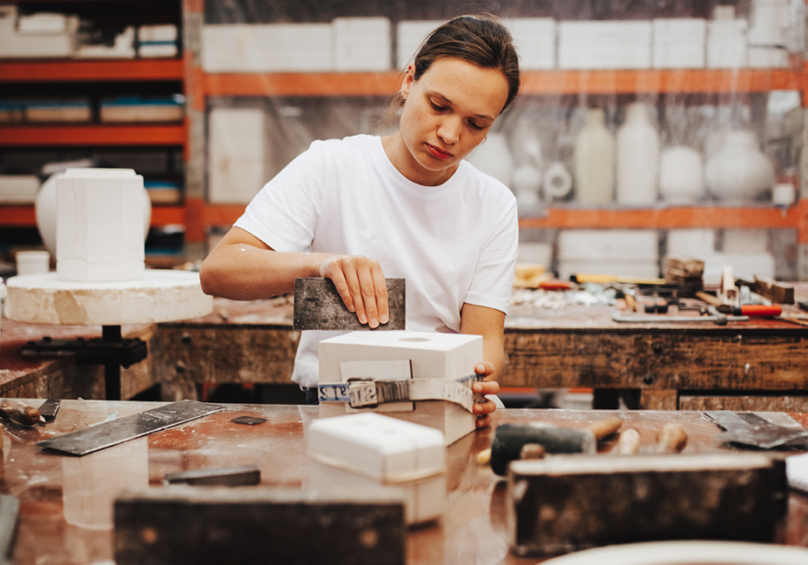 Jonge medewerker van Royal Delft werkt aan een gipsmal in de fabriek