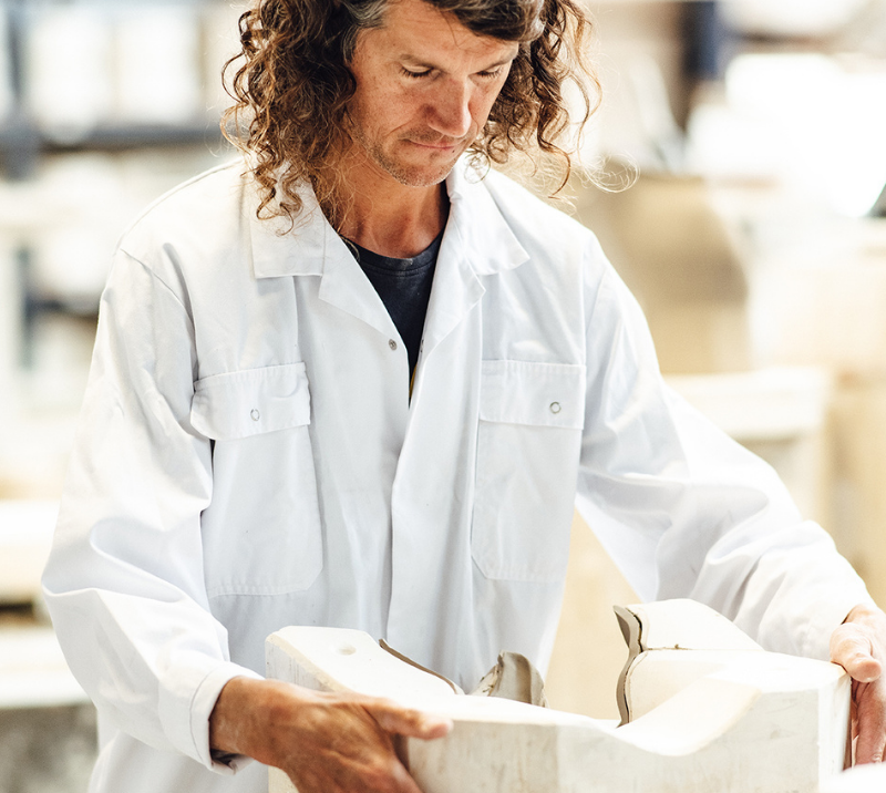 Medewerker in witte jas met een gipsmal op de productieafdeling van Royal Delft