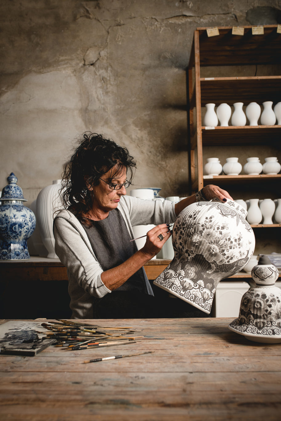 Royal Delft painter hand-painting a vase